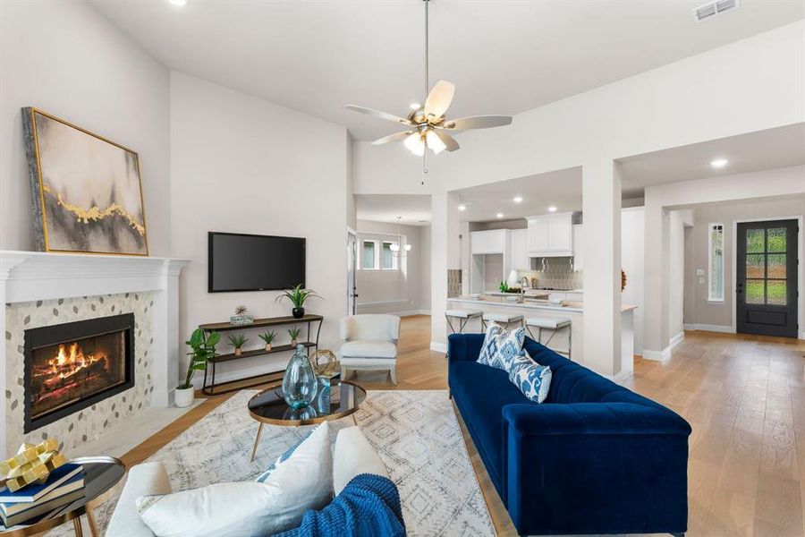 Living room featuring light hardwood / wood-style floors, a wealth of natural light, and a fireplace