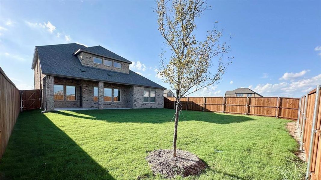 Back of property featuring brick siding, a shingled roof, a fenced backyard, and a patio area Back of property featuring brick siding, a shingled roof, a fenced backyard, and a patio area