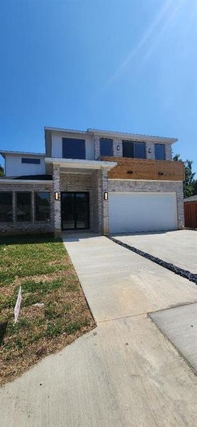 View of front of house with a front lawn and a garage