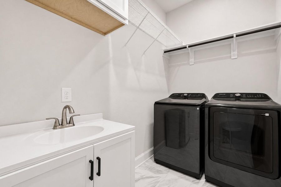 Large laundry room featuring built-in cabinetry and a sink, providing added storage, functionality, and everyday convenience Large laundry room featuring built-in cabinetry and a sink, providing added storage, functionality, and everyday convenience