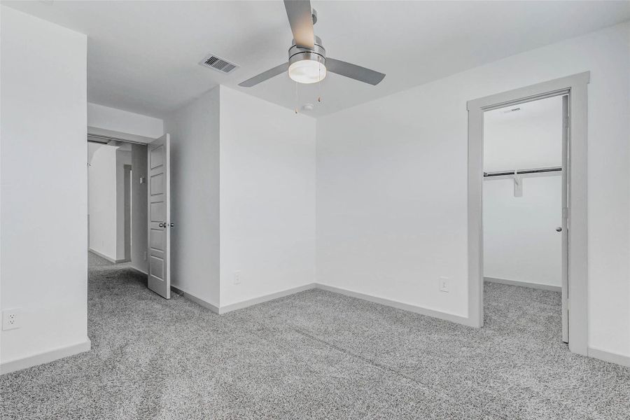 This well-sized bedroom includes plush carpet, modern ceiling fan, and walk-in closet access. Neutral tones and sleek finishes provide a comfortable canvas for any style, perfect as a guest room, home office, or personal retreat. This well-sized bedroom includes plush carpet, modern ceiling fan, and walk-in closet access. Neutral tones and sleek finishes provide a comfortable canvas for any style, perfect as a guest room, home office, or personal retreat.