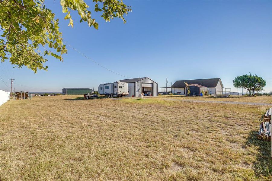 View of yard with a detached garage/workshop with electricity and plenty of RV/Boat storage View of yard with a detached garage/workshop with electricity and plenty of RV/Boat storage