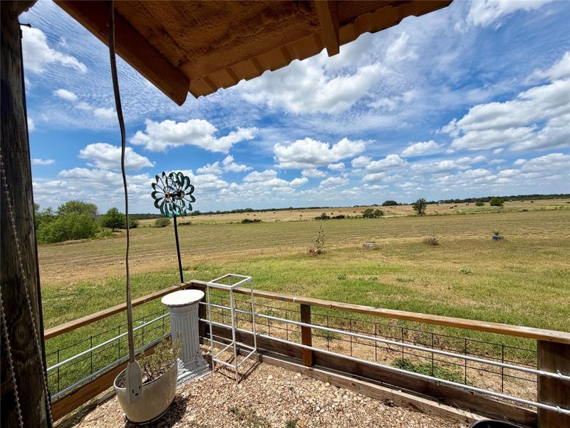 An inviting porch provides sweeping views of the verdant landscape, perfect for serene mornings or peaceful evenings.