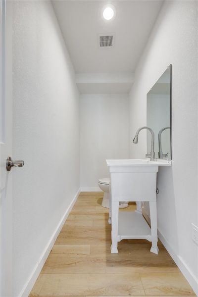 Bathroom with toilet and light wood-style floors Bathroom with toilet and light wood-style floors