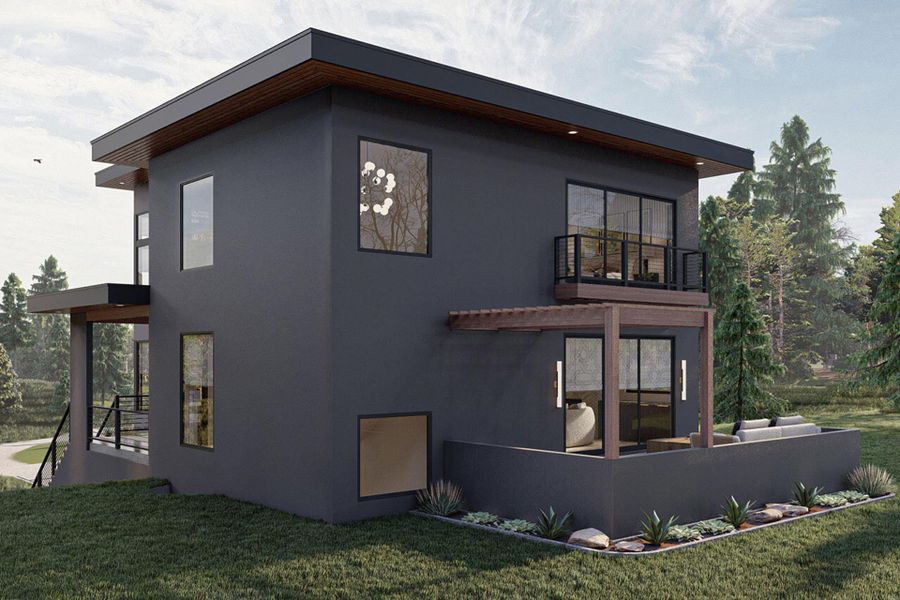 View of side of home with a yard, a balcony, and stucco siding