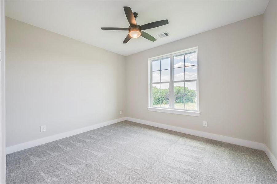 Unfurnished room featuring light colored carpet and ceiling fan