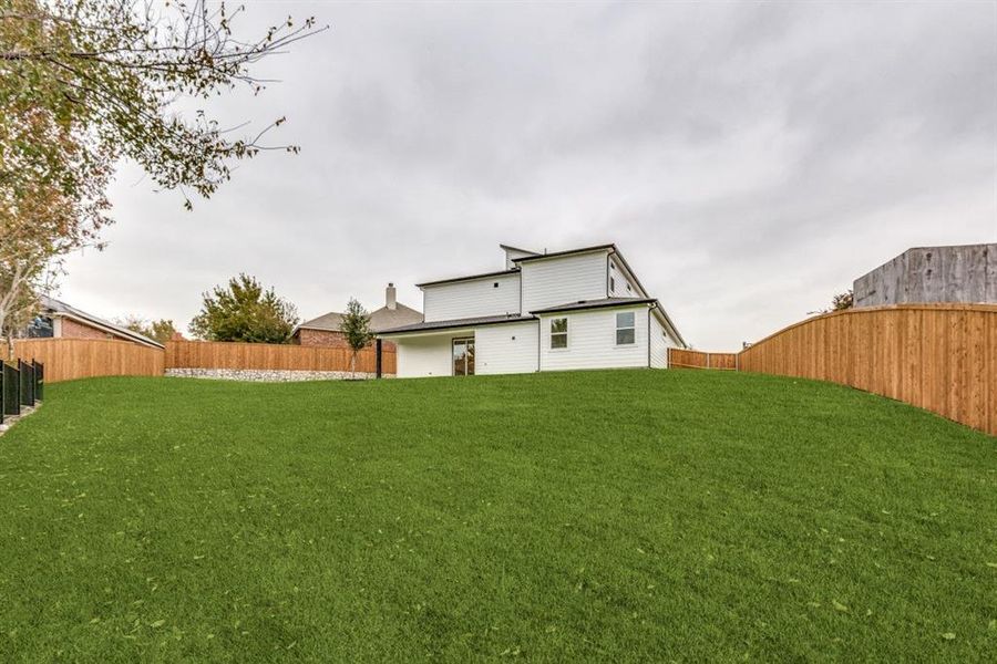 Rear view of house featuring a lawn