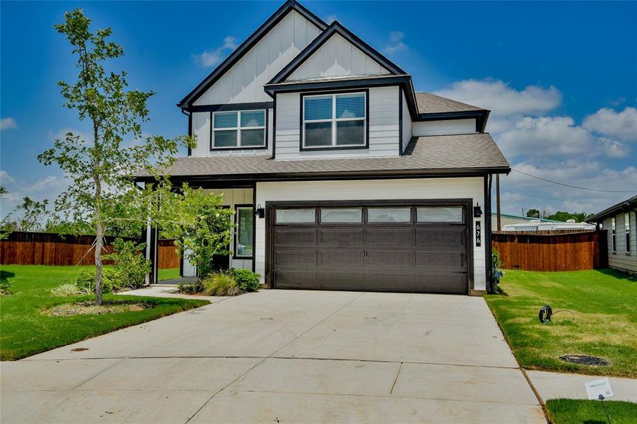 View of front of home with a shingled roof, board and batten siding, concrete driveway, and an attached garage View of front of home with a shingled roof, board and batten siding, concrete driveway, and an attached garage