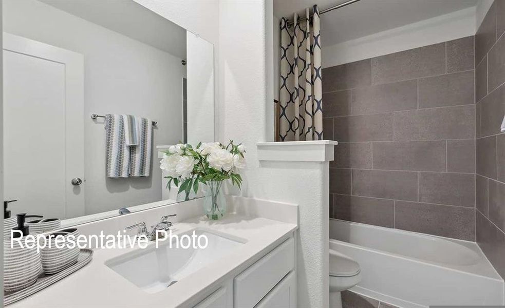 Full bathroom with shower / tub combo with curtain, vanity, and toilet