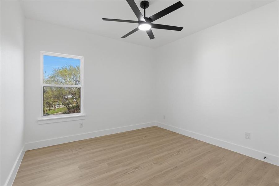 Empty room featuring light wood-style flooring and a ceiling fan
