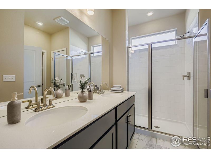 The primary bathroom featuring dual vanities