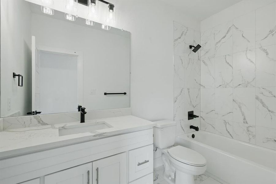 Bathroom with vanity, toilet,  shower combination, and marble finish floors