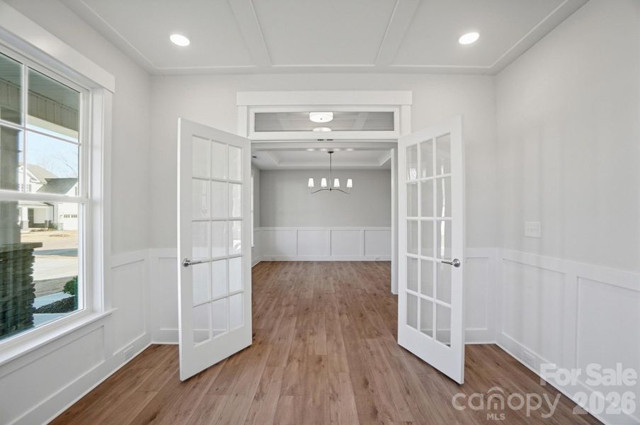 Office with faux coffered ceiling, French doors, and wainscoting