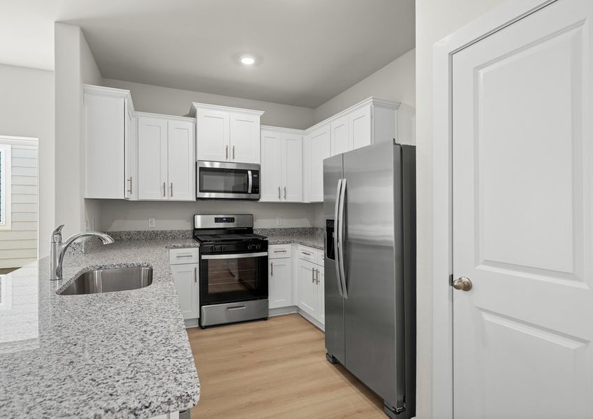 Beautiful kitchen includes granite counters, white cabinetry and stainless steel Whirlpool brand appliances. Beautiful kitchen includes granite counters, white cabinetry and stainless steel Whirlpool brand appliances.