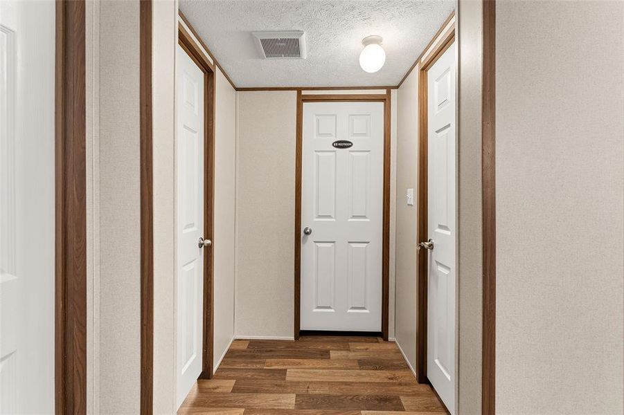 Hall with a textured ceiling and dark wood-style floors