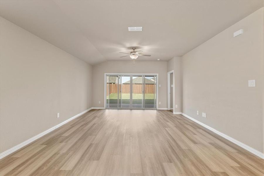 Unfurnished room featuring light wood-style floors, lofted ceiling, and ceiling fan Unfurnished room featuring light wood-style floors, lofted ceiling, and ceiling fan