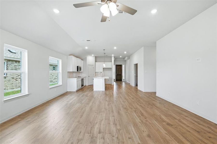Unfurnished living room featuring recessed lighting, light wood finished floors, and ceiling fan Unfurnished living room featuring recessed lighting, light wood finished floors, and ceiling fan