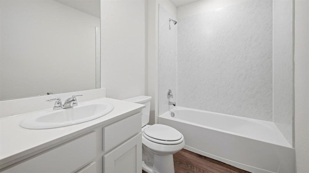 Full bath with vanity, shower / washtub combination, and dark wood-style floors Full bath with vanity, shower / washtub combination, and dark wood-style floors