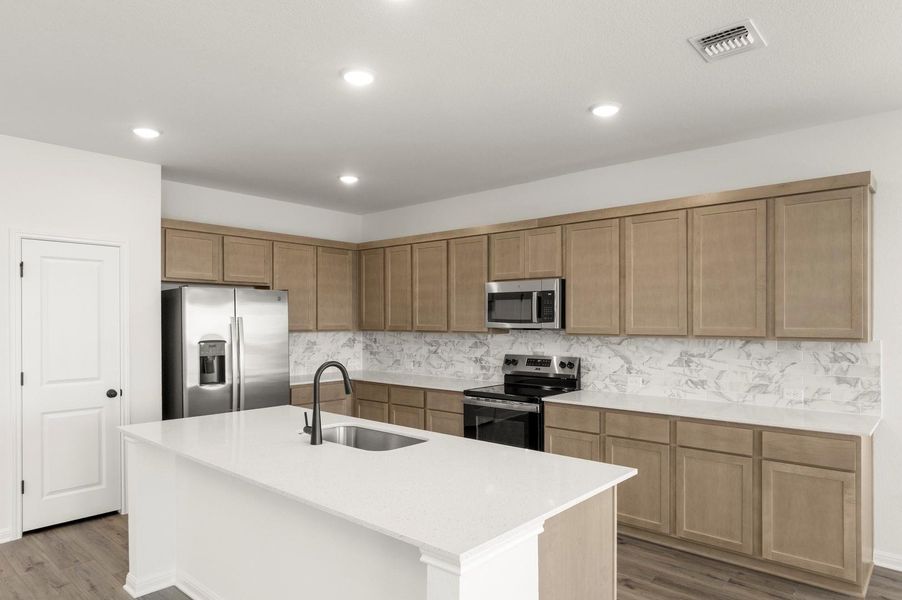 Kitchen with appliances with stainless steel finishes, dark wood finished floors, light stone counters, tasteful backsplash, and recessed lighting