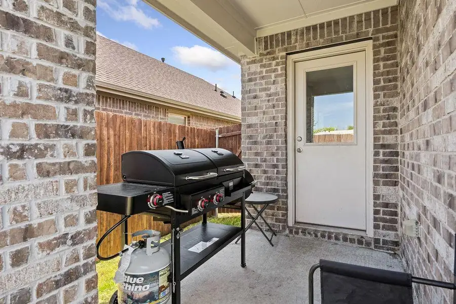 Covered patio with concrete flooring, brick exterior walls, and a privacy fence Covered patio with concrete flooring, brick exterior walls, and a privacy fence