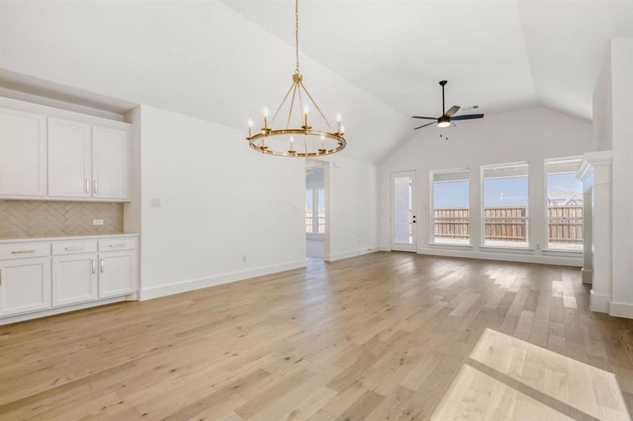 Unfurnished living room featuring ceiling fan, suspended lighting, and light wood-type flooring