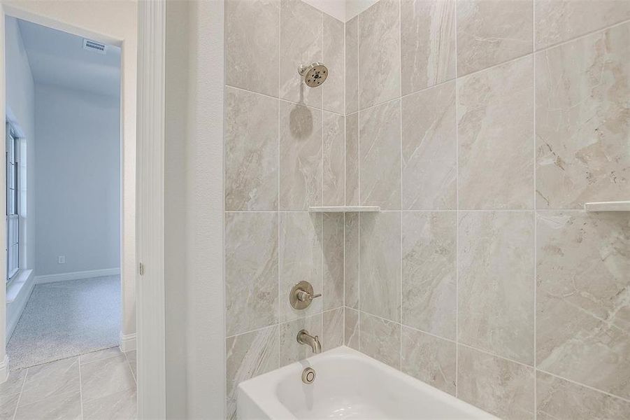 Bathroom featuring tile patterned flooring and tiled shower / bath