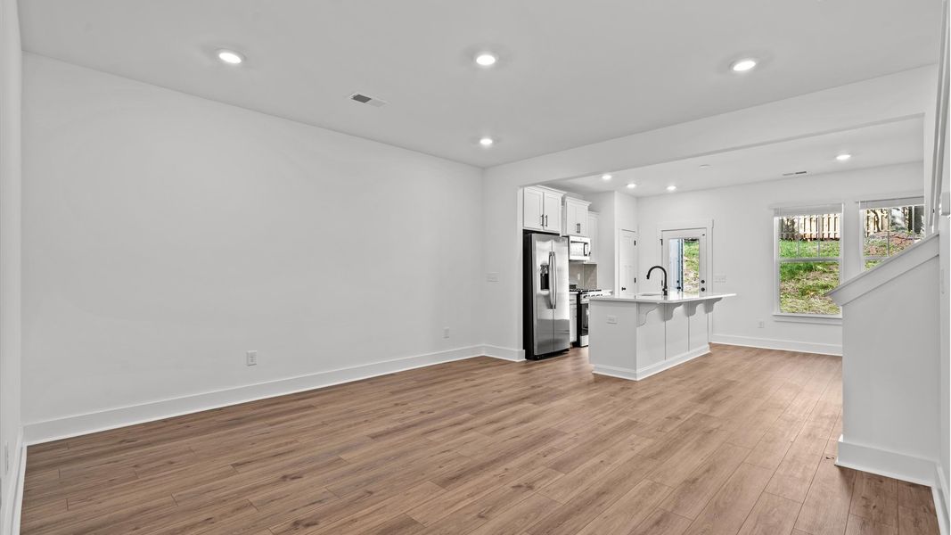 Elegant family room featuring hardwood flooring, large windows, and thoughtful architectural detail