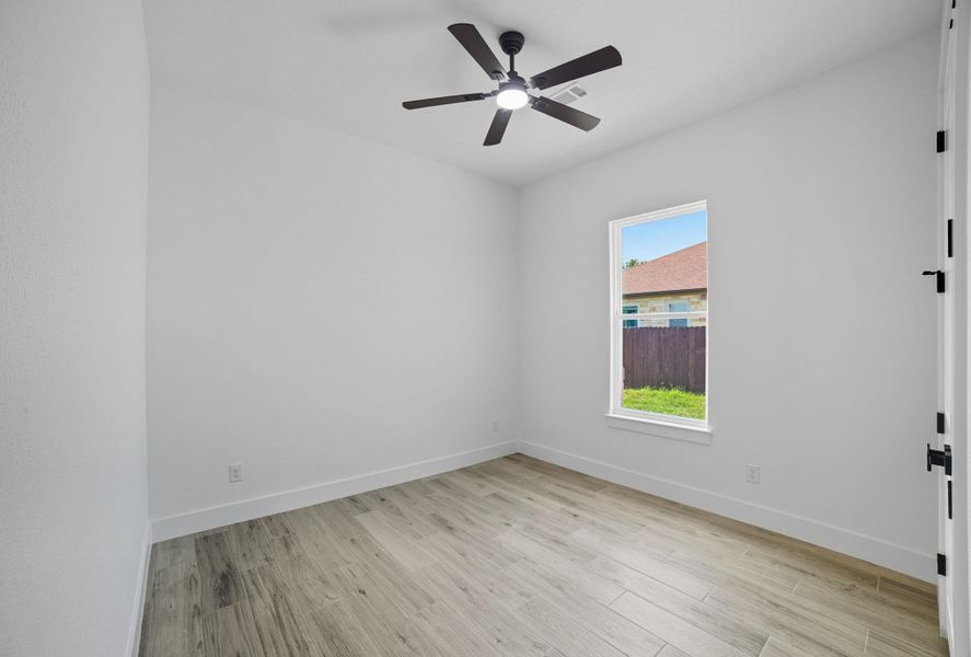 Unfurnished room with light wood-style flooring and a ceiling fan Unfurnished room with light wood-style flooring and a ceiling fan