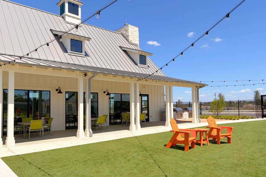 A spacious covered patio seamlessly transitions to a manicured lawn under a modern metal roof.