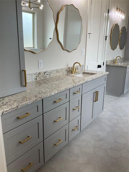 Abundant storage in this primary bath with dual vanities and loads of cabinet drawers