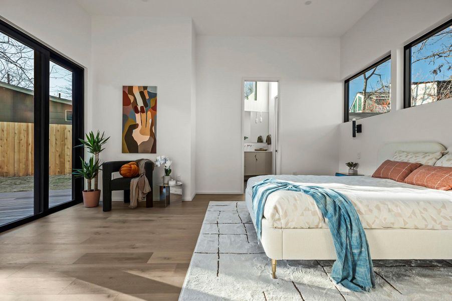 Primary bedroom with sliding doors to exterior deck and en suite bathroom Primary bedroom with sliding doors to exterior deck and en suite bathroom