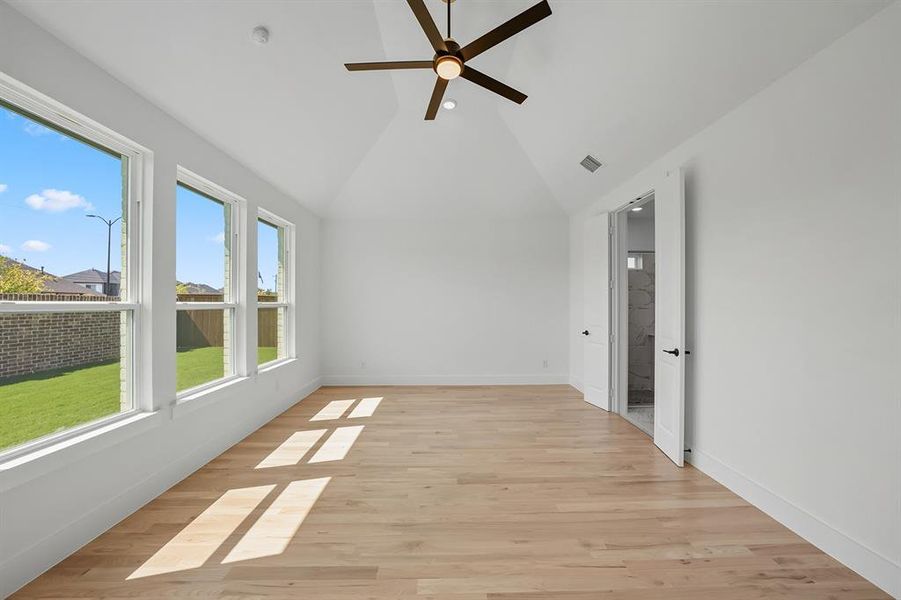 Unfurnished sunroom featuring wood finished floors and high vaulted ceiling