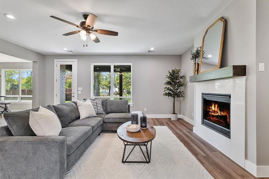 Living room with hardwood / wood-style flooring, a fireplace, and ceiling fan