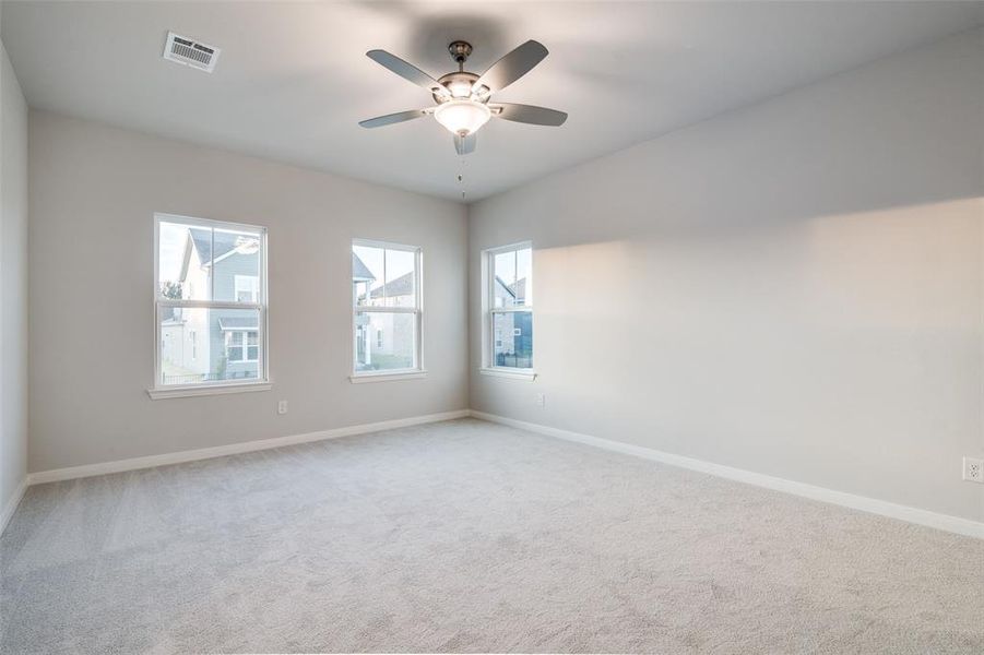 Carpeted spare room featuring ceiling fan