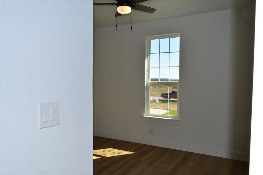 Spare room with dark wood finished floors and a ceiling fan Spare room with dark wood finished floors and a ceiling fan