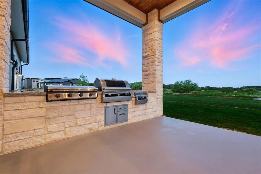 Patio terrace at dusk featuring an outdoor kitchen and a patio area Patio terrace at dusk featuring an outdoor kitchen and a patio area