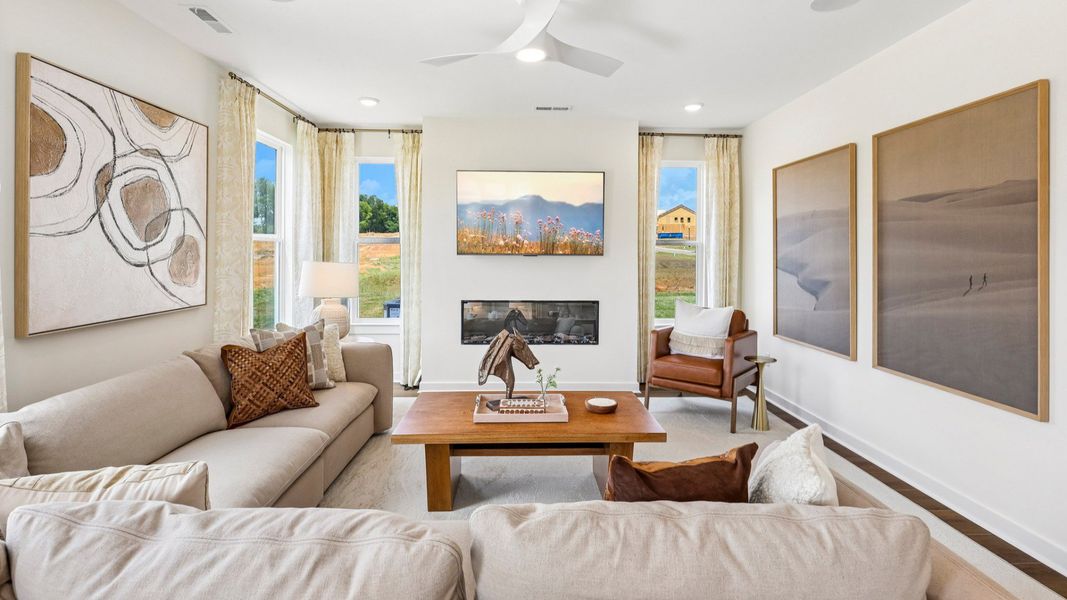 Gathering room with ceiling fan, windows, and fireplace