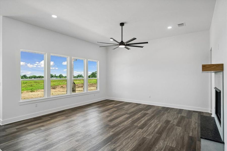 Unfurnished living room with ceiling fan, dark wood-style floors, recessed lighting, and a fireplace