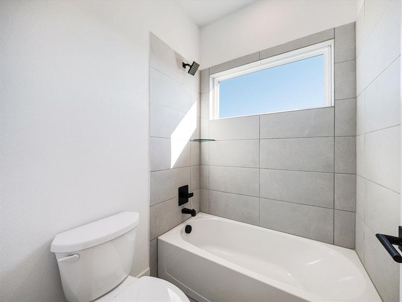 Bathroom featuring shower / bath combination and toilet