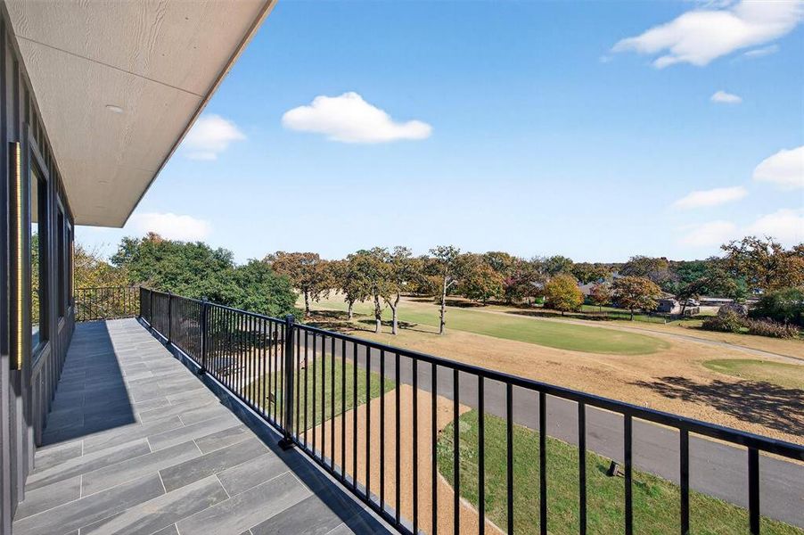 Balcony featuring view of golf course and view of scattered trees
