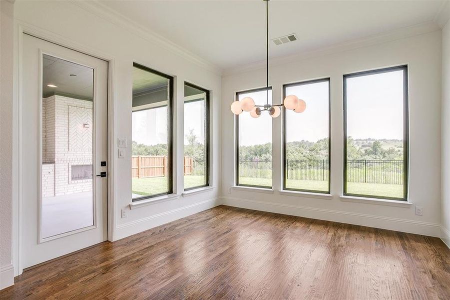 Unfurnished dining area with dark hardwood / wood-style floors, an inviting chandelier, and crown molding