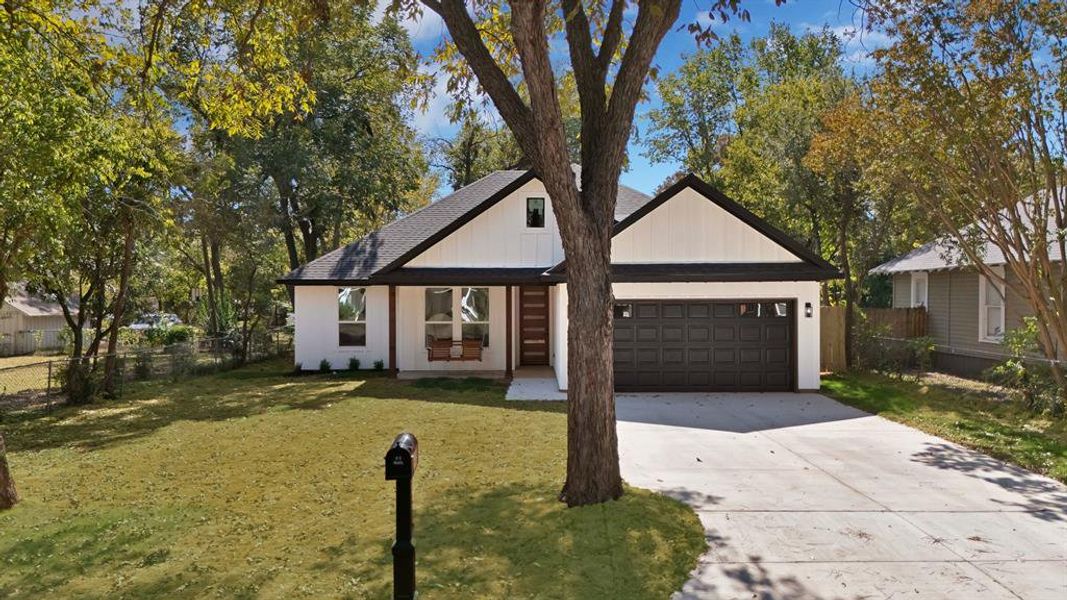 Modern farmhouse style home featuring concrete driveway, a shingled roof, a garage, and board and batten siding