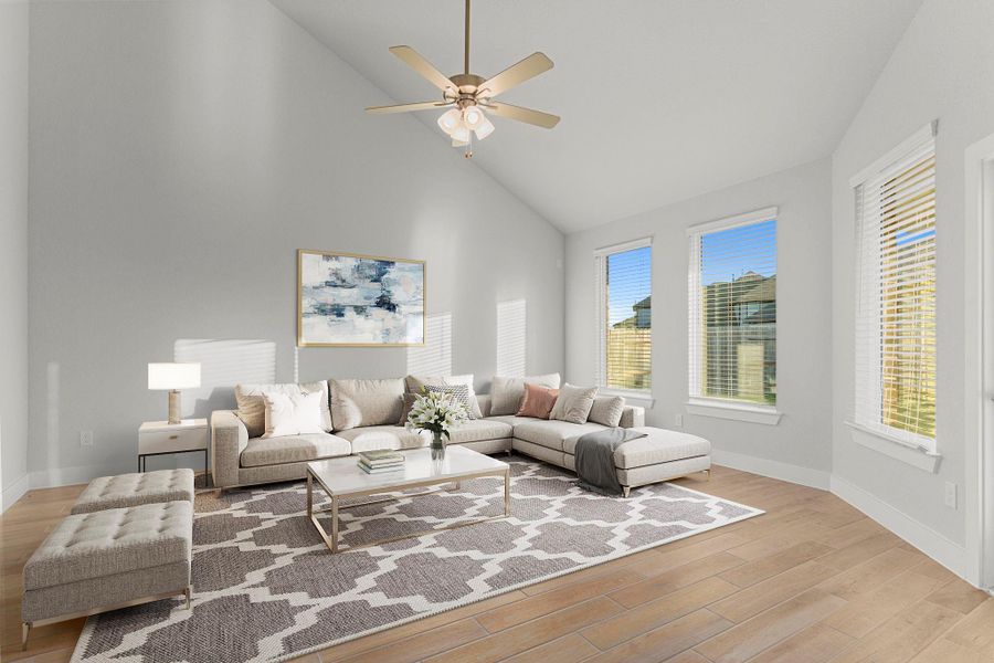 The family room offers a bright and spacious retreat with soaring ceilings, wood-like tile flooring, and a wall of windows overlooking the backyard—creating the perfect gathering spot for relaxing or entertaining. *Staged Photo* The family room offers a bright and spacious retreat with soaring ceilings, wood-like tile flooring, and a wall of windows overlooking the backyard—creating the perfect gathering spot for relaxing or entertaining. *Staged Photo*