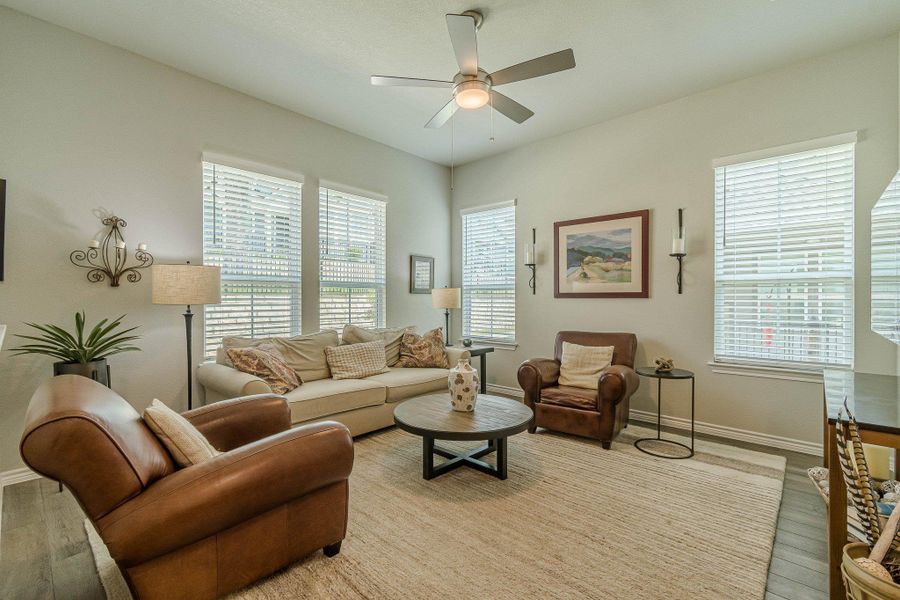 Living area featuring ceiling fan, light wood-type flooring, and baseboards