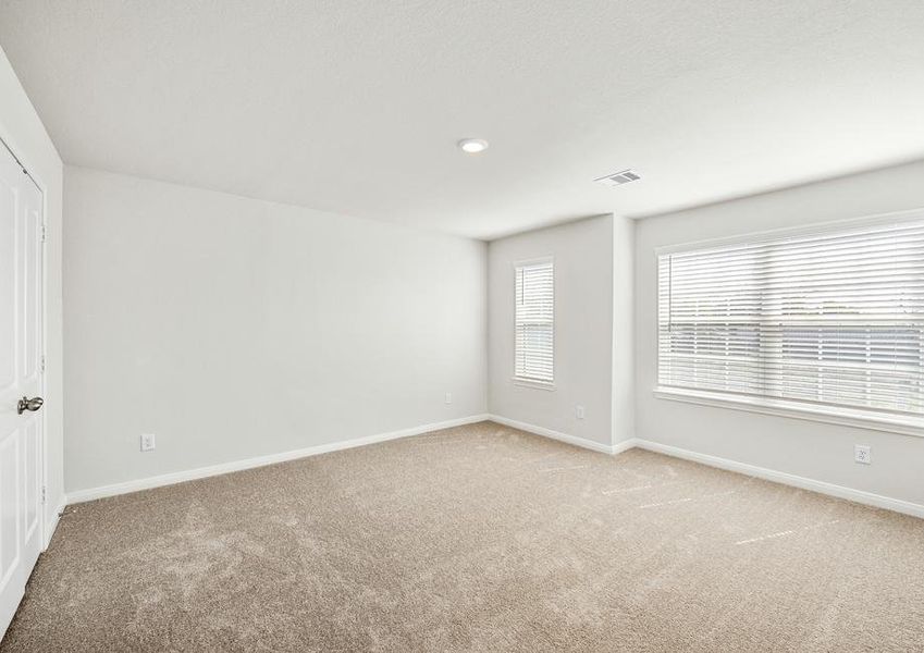 The master bedroom has large windows and carpet.