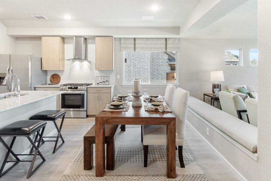 Open-concept kitchen and dining area with wood table, stainless appliances, and light wood cabinets Open-concept kitchen and dining area with wood table, stainless appliances, and light wood cabinets