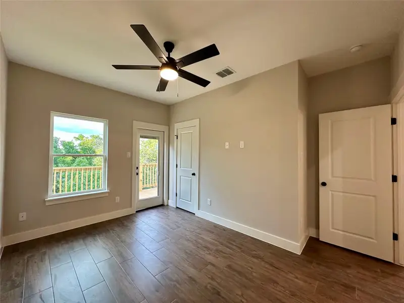 Empty room featuring dark wood-style floors and a ceiling fan