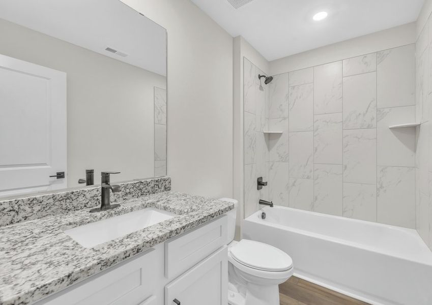 The secondary bathroom comes with a large soaking tub.