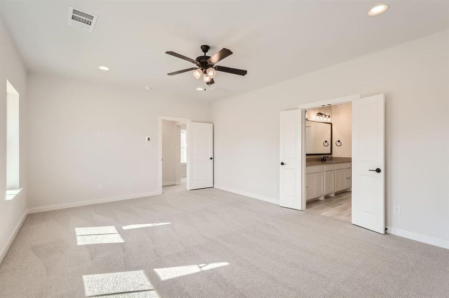 Unfurnished bedroom with sink, ceiling fan, light carpet, and ensuite bath