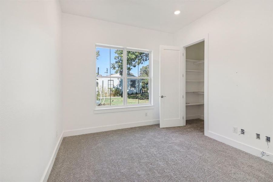 Unfurnished bedroom with a spacious closet, carpet flooring, and recessed lighting